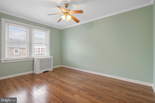 empty room with hardwood / wood-style floors, ceiling fan, radiator heating unit, and ornamental molding