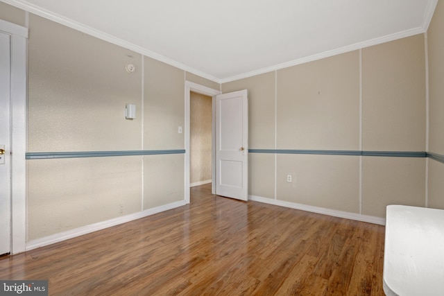 empty room with hardwood / wood-style floors and ornamental molding