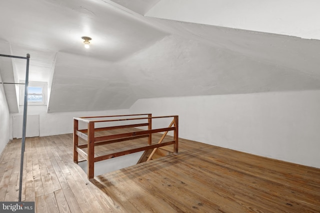 bonus room with vaulted ceiling and hardwood / wood-style flooring