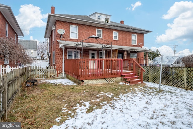 snow covered rear of property featuring a deck