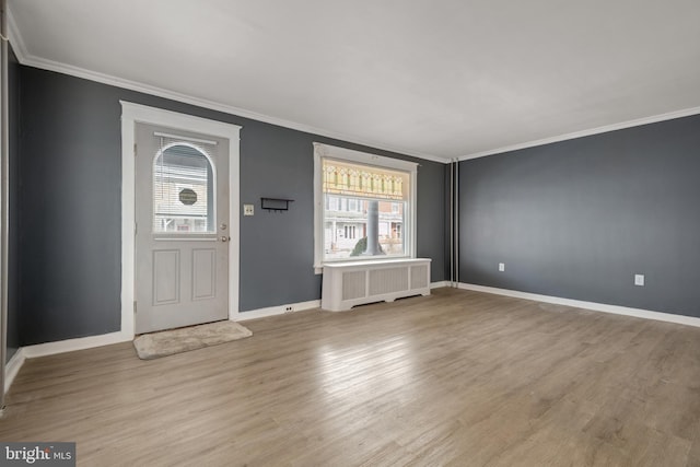 entrance foyer with light hardwood / wood-style flooring, radiator, and ornamental molding