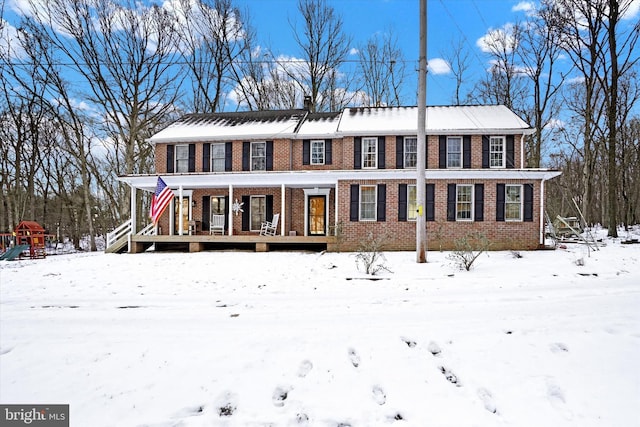 view of front facade with a porch, playground community, and brick siding