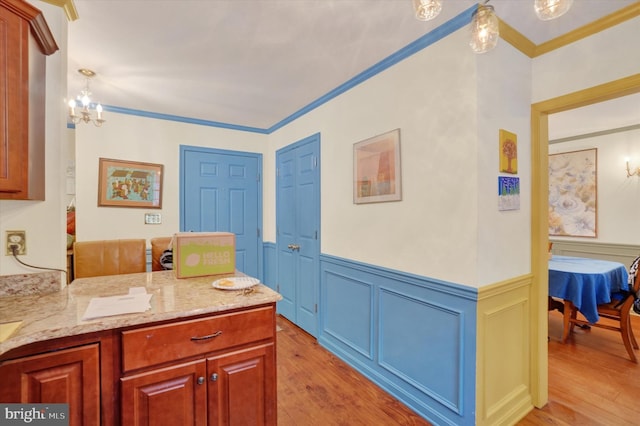 bathroom featuring an inviting chandelier, crown molding, and wood-type flooring