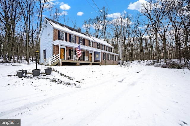 view of front of home featuring brick siding and a chimney