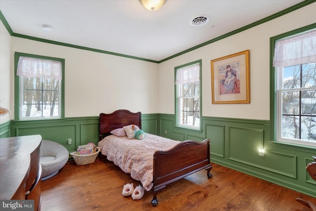 bedroom featuring hardwood / wood-style floors and crown molding