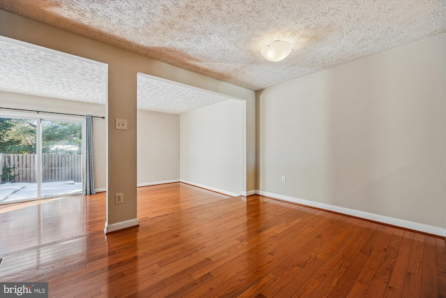 empty room featuring a textured ceiling and hardwood / wood-style floors