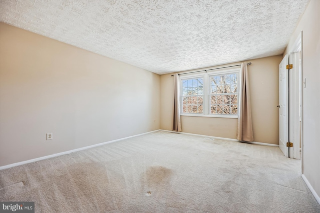 carpeted empty room featuring a textured ceiling