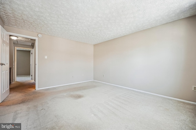 empty room featuring a textured ceiling and light carpet