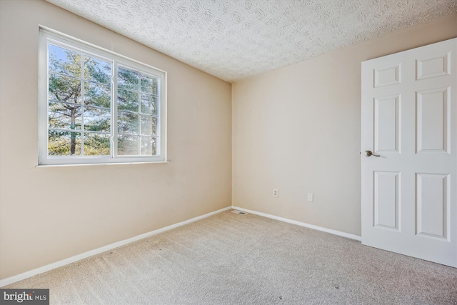 carpeted spare room featuring a textured ceiling