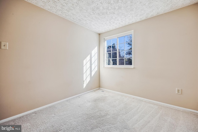 spare room with a textured ceiling and carpet flooring