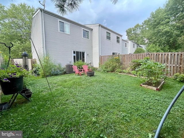 rear view of property with a lawn and central AC