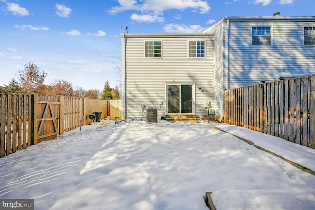 snow covered rear of property with central air condition unit