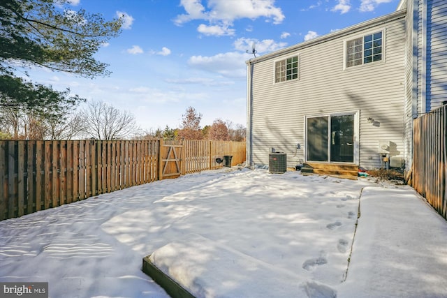 snow covered house featuring central air condition unit