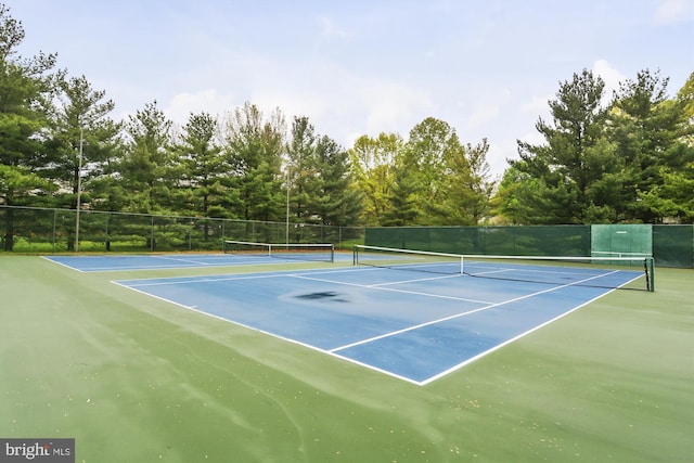 view of tennis court featuring basketball hoop