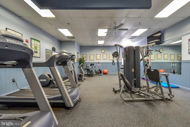 exercise room featuring ceiling fan and a drop ceiling