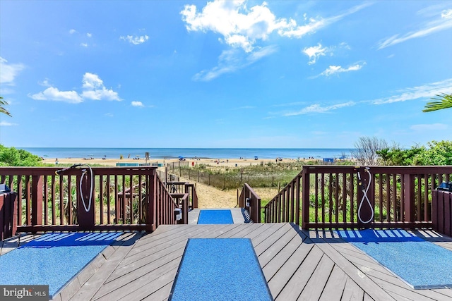 wooden deck with a view of the beach and a water view