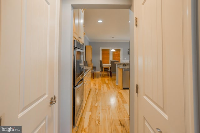 kitchen featuring pendant lighting, crown molding, light hardwood / wood-style flooring, and dishwasher