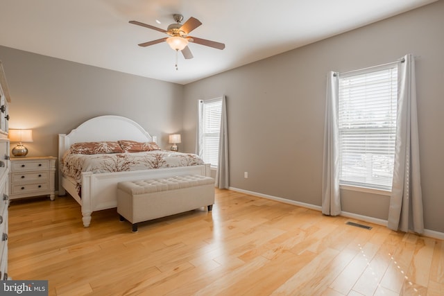 bedroom featuring multiple windows, ceiling fan, and light hardwood / wood-style floors