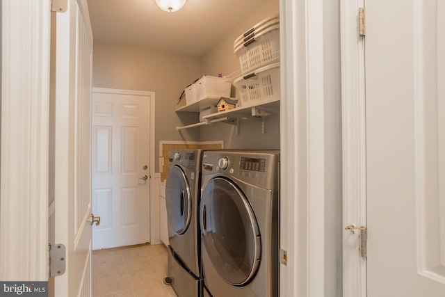 laundry area featuring washing machine and dryer and light tile patterned flooring