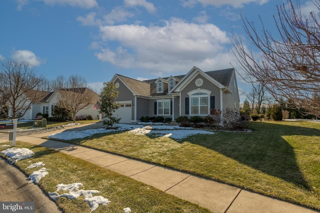 view of property with a garage and a front lawn