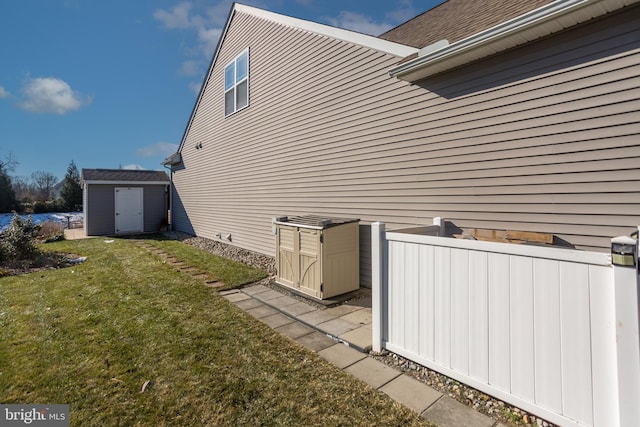 view of side of home featuring a storage shed and a lawn