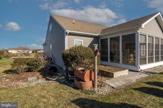 rear view of house with a yard and a sunroom