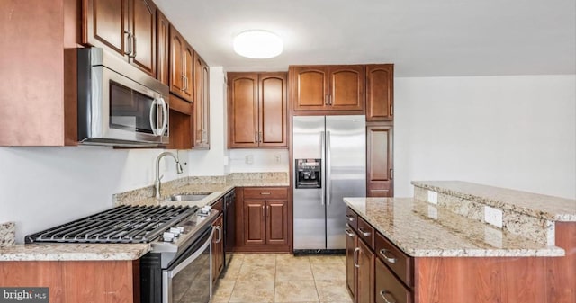 kitchen with sink, light stone counters, light tile patterned floors, and stainless steel appliances