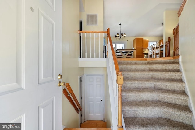 stairs featuring a notable chandelier