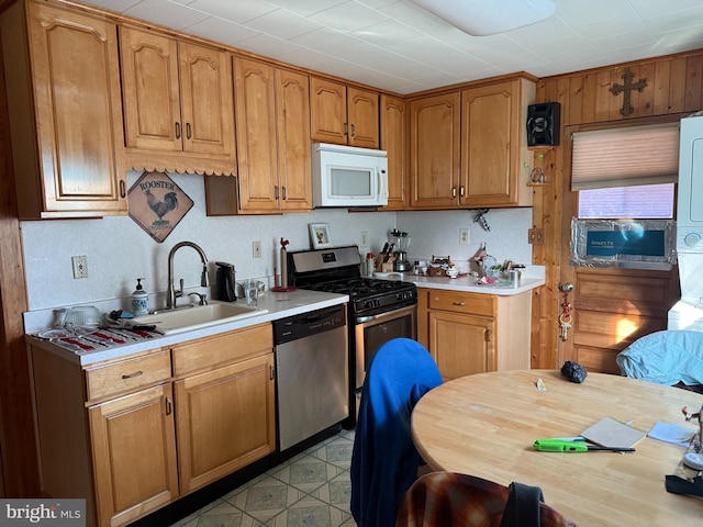 1901 Walnut Ave, Dundalk, MD 21222 - kitchen featuring appliances with stainless steel finishes, a sink, light countertops, brown cabinetry, and light flooring