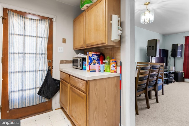 kitchen with a wealth of natural light, pendant lighting, and tasteful backsplash