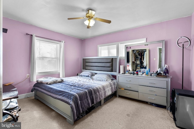 bedroom with ceiling fan and light carpet