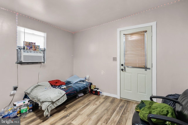 bedroom with cooling unit and wood-type flooring