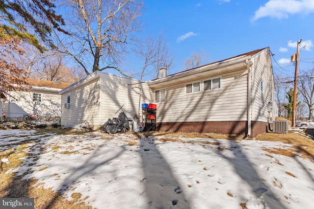 snow covered property featuring central AC