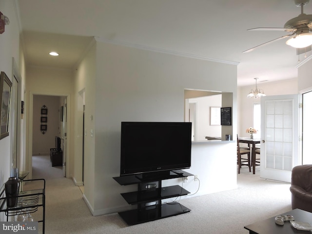 living room with light colored carpet, ceiling fan with notable chandelier, and ornamental molding