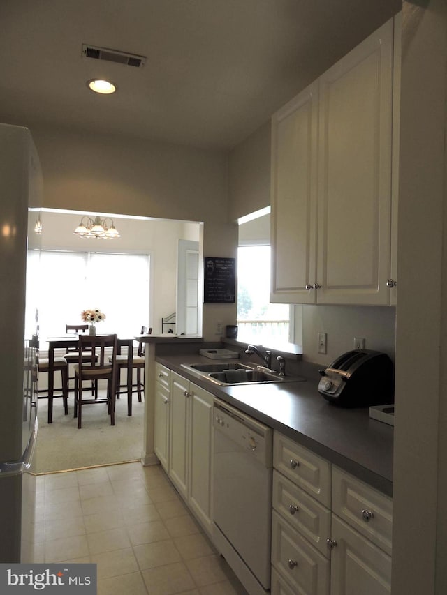 kitchen with white cabinets, sink, and white dishwasher