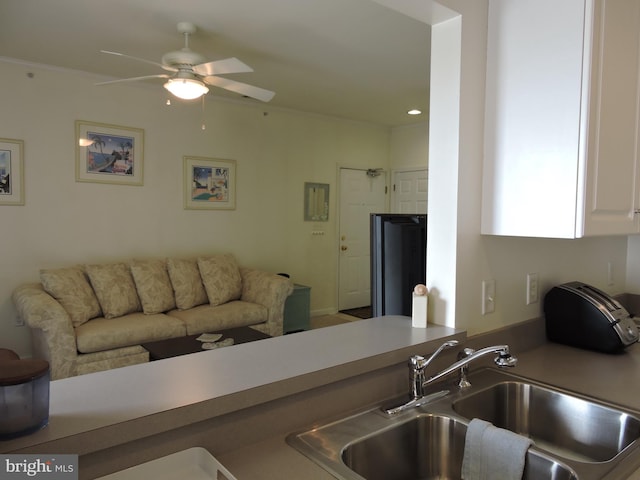 kitchen featuring white cabinets, ceiling fan, and sink