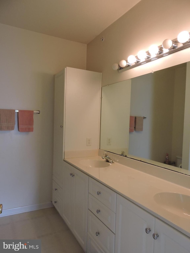 bathroom featuring toilet, vanity, and tile patterned floors