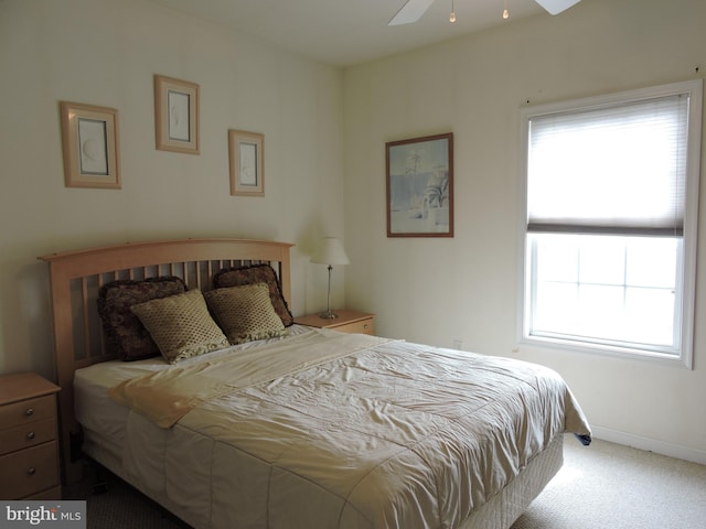 carpeted bedroom featuring multiple windows and ceiling fan