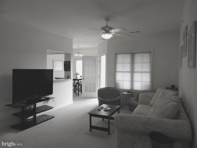 carpeted living room featuring crown molding and ceiling fan with notable chandelier