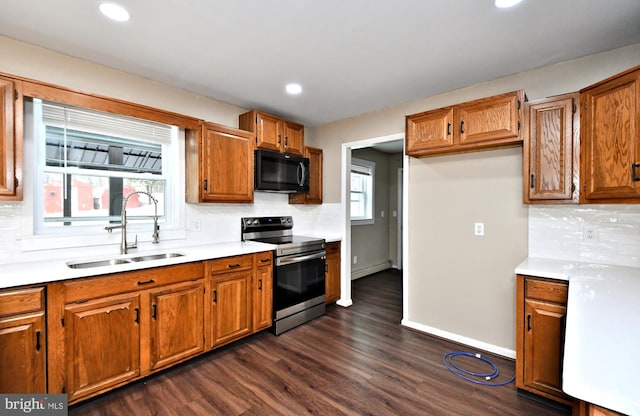 kitchen with decorative backsplash, dark hardwood / wood-style floors, electric range, and sink