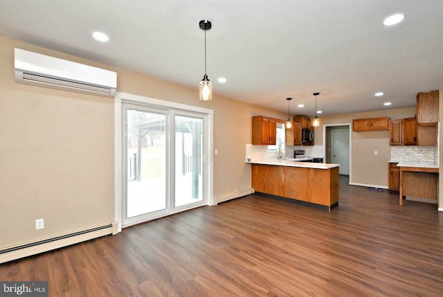 kitchen featuring kitchen peninsula, sink, a wall mounted air conditioner, hanging light fixtures, and dark wood-type flooring