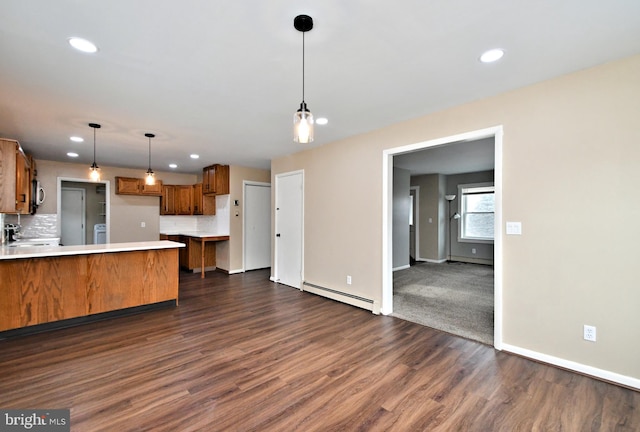 kitchen featuring kitchen peninsula, a baseboard heating unit, decorative backsplash, dark hardwood / wood-style flooring, and hanging light fixtures