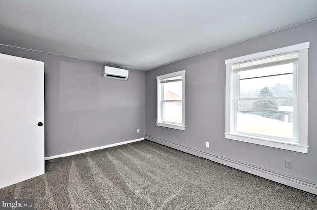 spare room with a baseboard heating unit, a wall unit AC, and dark carpet