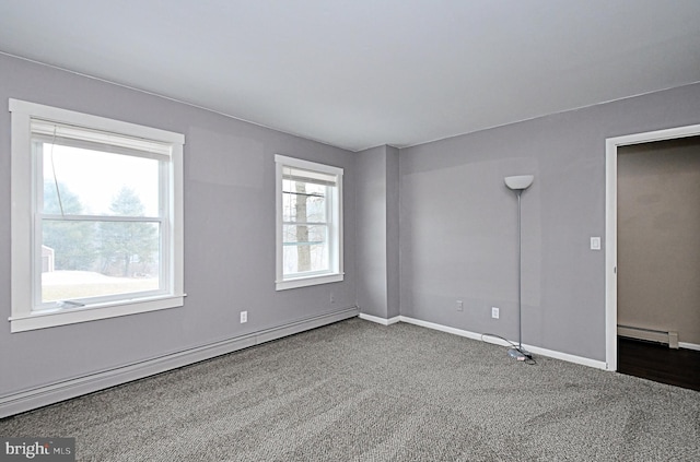 spare room featuring a baseboard heating unit and carpet flooring