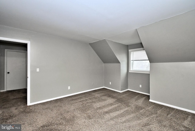 bonus room featuring lofted ceiling and dark colored carpet