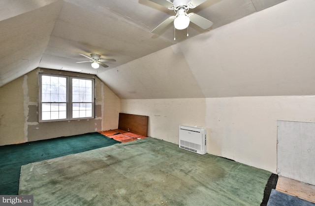 additional living space with ceiling fan, dark colored carpet, and lofted ceiling