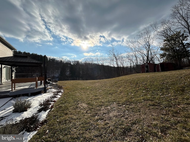 view of yard with a wooden deck, a gazebo, and a storage unit