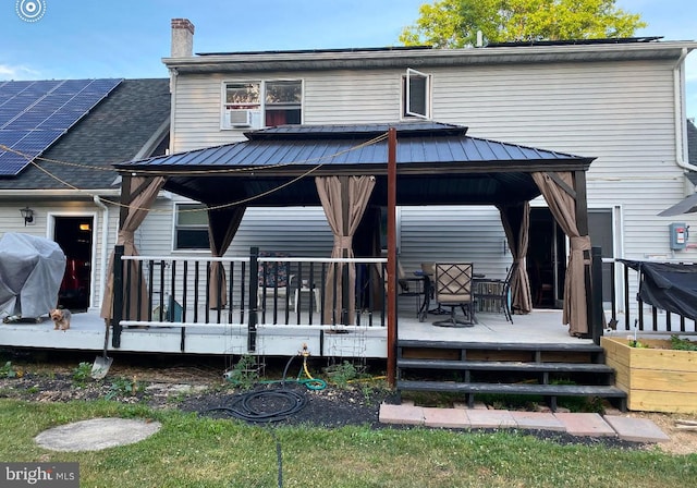 rear view of house with a gazebo and a wooden deck