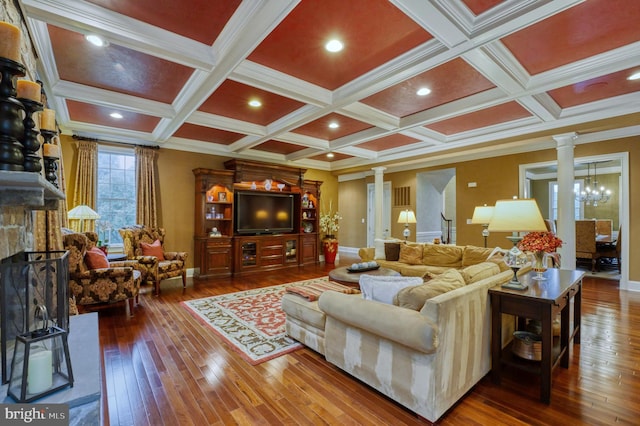 living room with hardwood / wood-style flooring, a fireplace, decorative columns, and beamed ceiling