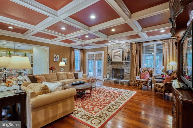 living room featuring a fireplace, beamed ceiling, hardwood / wood-style flooring, ornamental molding, and coffered ceiling